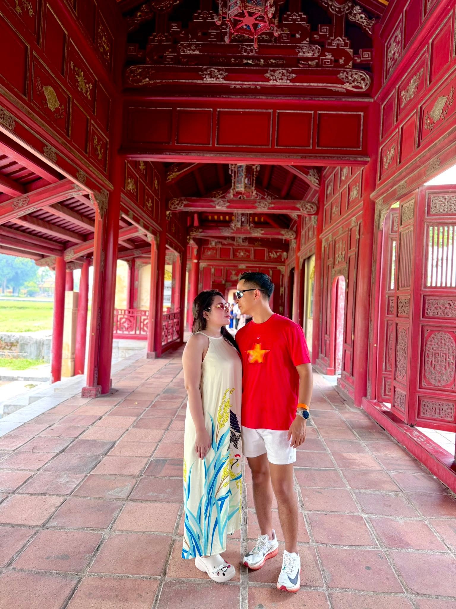 Dương Cao Trí và vợ nhìn nhau tình cảm dưới mái hiên đỏ ở Đại Nội Huế