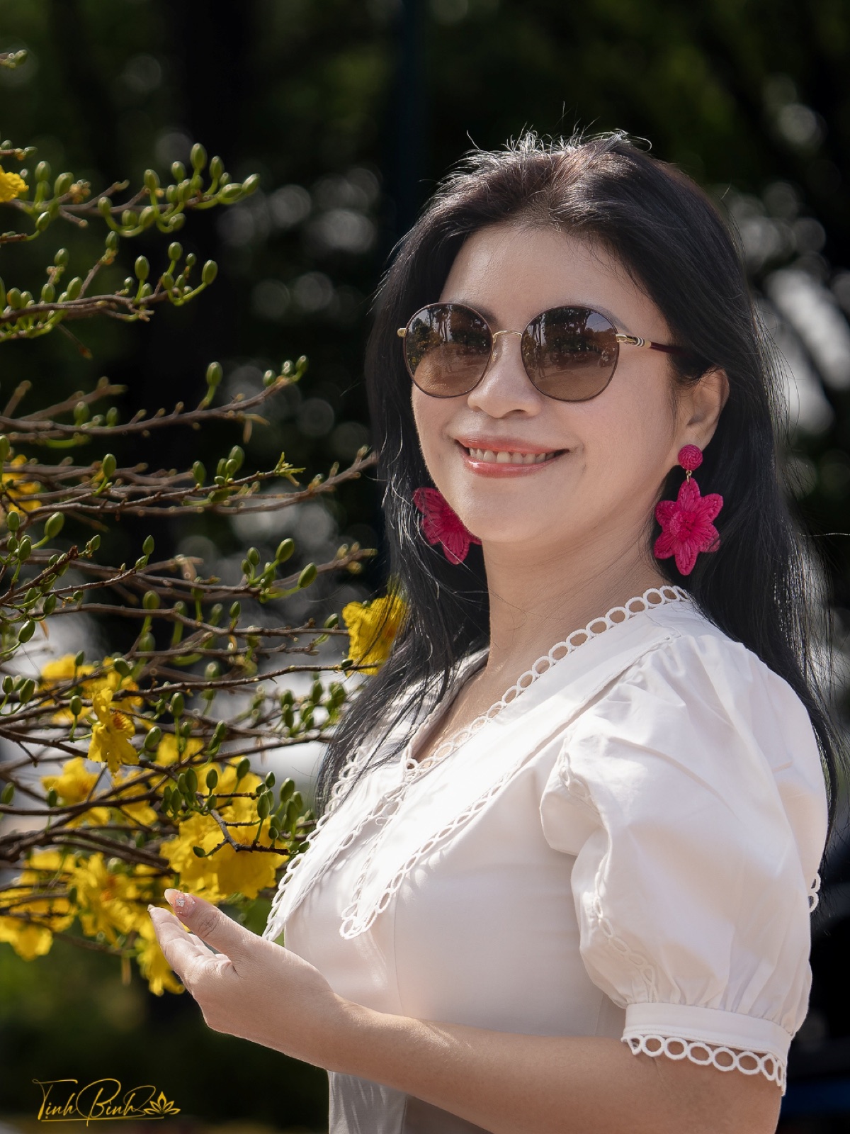 Lê Nguyên Trang Nhã tươi cười bên cành hoa mai vàng ngày Tết